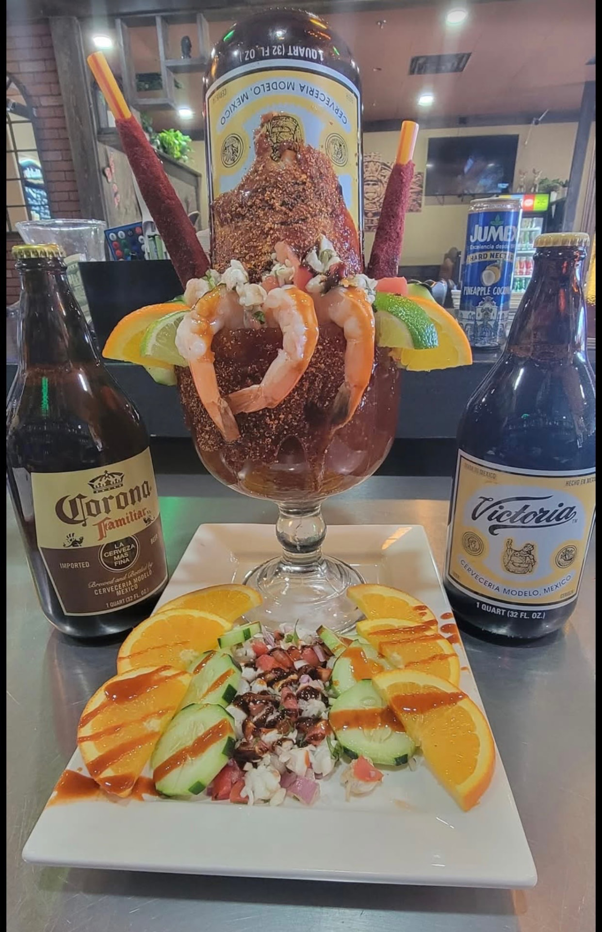 Giant chili-rimmed michelada goblet with shrimp, ceviche, tamarind straws, Corona and Victoria beers