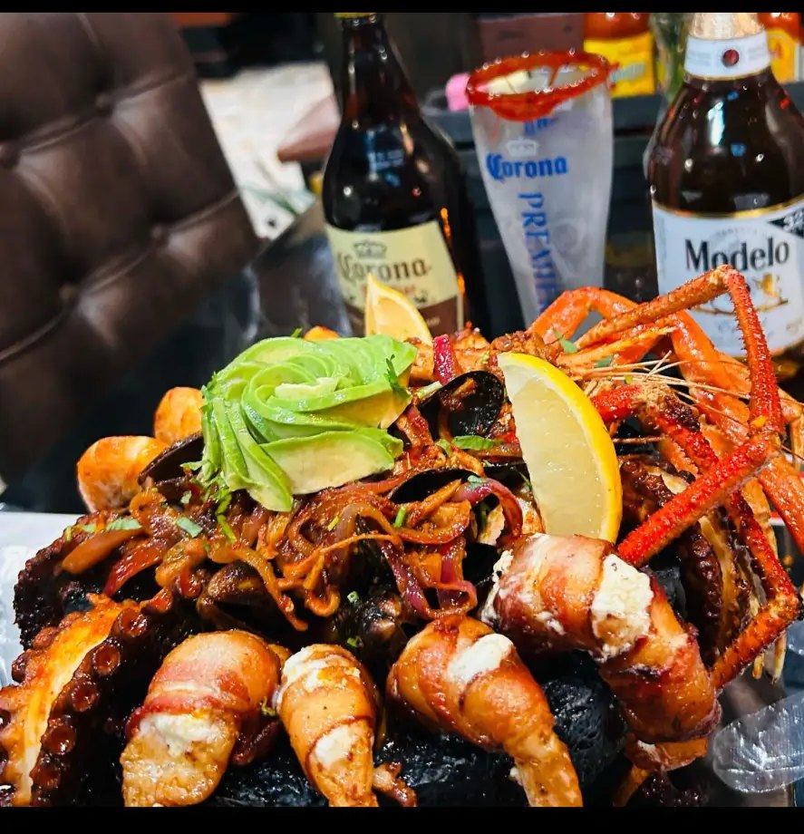 Molcajete Pikantes de Mariscos Momia with grilled octopus, bacon-wrapped shrimp, avocado and crab legs