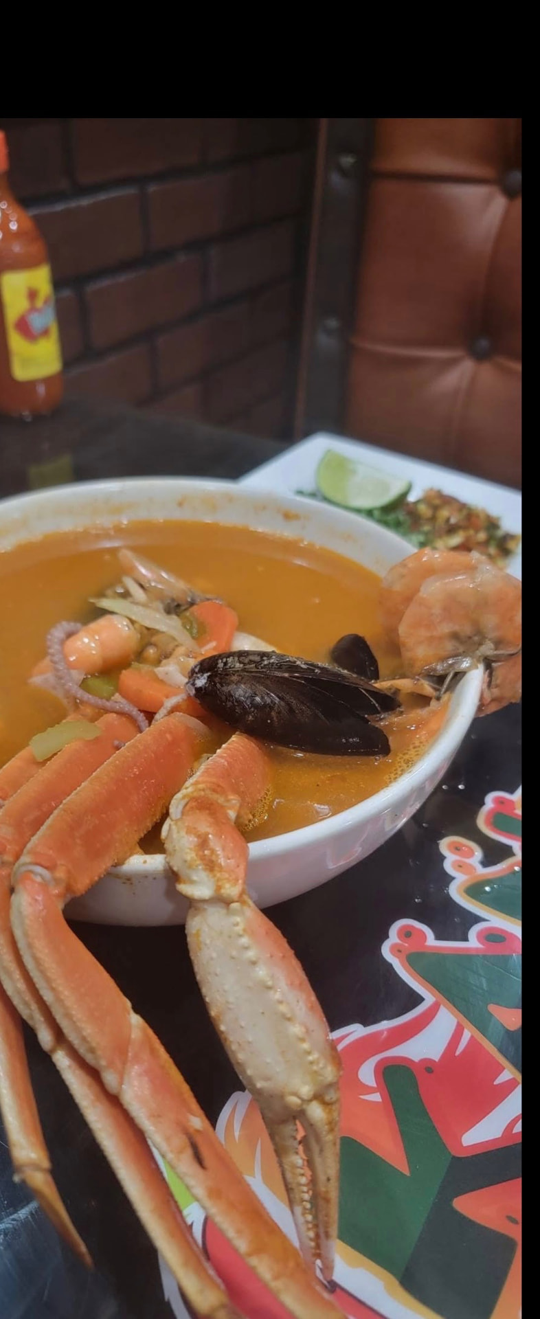 Seafood soup with snow crab legs, shrimp, mussels and octopus in a rich red broth